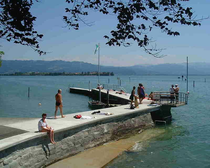 Badegäste auf dem Steg des Seebads im Sommer
